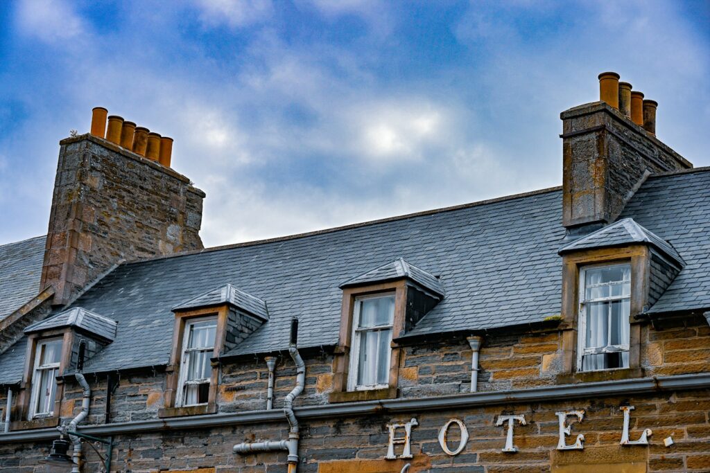 Stone hotel building with dormer windows and chimneys