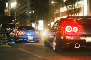 Sports cars driving on a city street at night