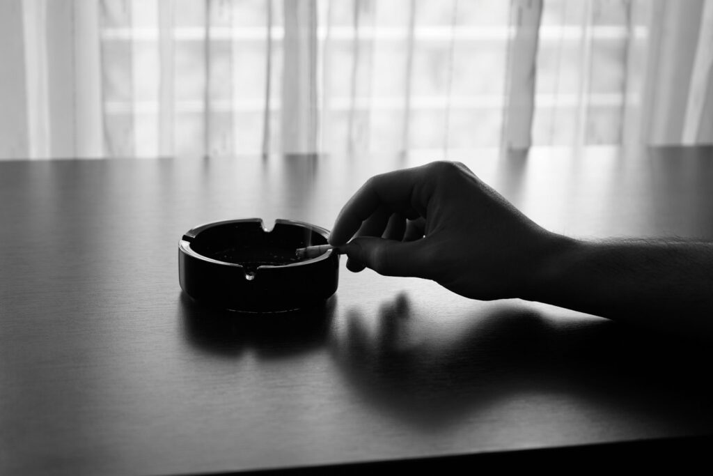 A black and white photo of a person's hand reaching for something in a