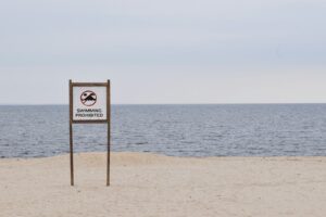 brown and white beach signage on beach during daytime